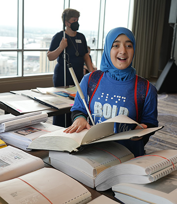 Narjis smiles while checking out a new Braille book.